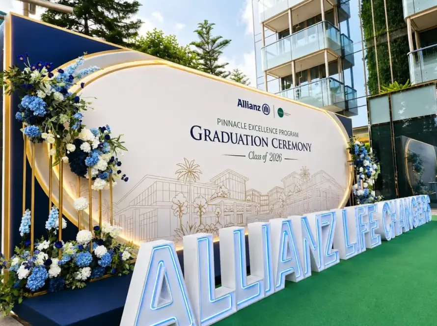 Graduation ceremony backdrop with blue and white floral arrangements and LED marquee letters in Singapore
